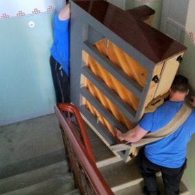 Pystypianoa kuljetetaan kerrostalon portaissa